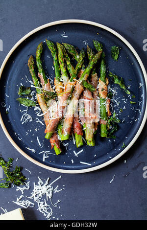 Gegrillter Spargel, eingehüllt in Parma-Schinken mit Parmesan, Salbei und Thymian Stockfoto