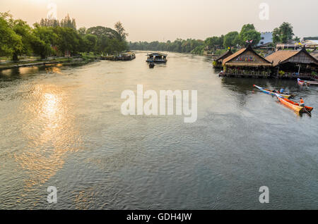 Erhöhte Ansicht von der Brücke, schöne Landschaft des Kwai Yai Fluss bei Sonnenuntergang und Lebensweise der Menschen an der Uferpromenade in Kancha Stockfoto