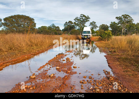 Das Wasser über eine unbefestigte Straße nach etwas Regen im Outback. Stockfoto