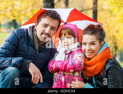 Glückliche junge Familie unter einem Dach in einem herbstlichen park Stockfoto