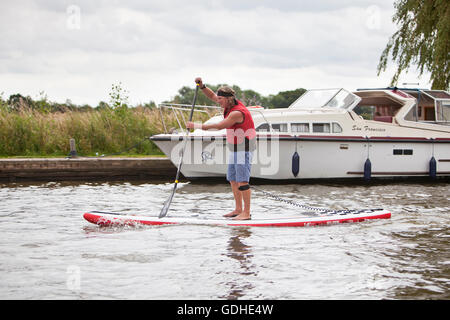 Norfolk Broads, UK. 16. Juli 2016. Das sechste Norfolk Broads klassische SUP Rennen. Zehn und fünf Meile Kurse zwischen wie Hill Nature Reserve und Martham vorbei an den Ruinen von St. Benets Abbey, Thurne Windmühle und unter niedrigen mittelalterliche Brücke bei Potter Heigham, unzählige Urlaub Cruiser und Yachten auf dem Weg zu verhandeln. Mit Ursprung in Hawaii als Sport, Stand-up-Paddle-Boarding ist einer der neuesten Wassersport Großbritanniens und das Broads Classic, organisiert von Martham Boote, zieht Anfänger und erfahrene Rennfahrer aus der ganzen Land. Bildnachweis: Adrian Buck/Alamy Live-Nachrichten Stockfoto