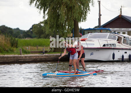 Norfolk Broads, UK. 16. Juli 2016. Das sechste Norfolk Broads klassische SUP Rennen. Zehn und fünf Meile Kurse zwischen wie Hill Nature Reserve und Martham vorbei an den Ruinen von St. Benets Abbey, Thurne Windmühle und unter niedrigen mittelalterliche Brücke bei Potter Heigham, unzählige Urlaub Cruiser und Yachten auf dem Weg zu verhandeln. Mit Ursprung in Hawaii als Sport, Stand-up-Paddle-Boarding ist einer der neuesten Wassersport Großbritanniens und das Broads Classic, organisiert von Martham Boote, zieht Anfänger und erfahrene Rennfahrer aus der ganzen Land. Bildnachweis: Adrian Buck/Alamy Live-Nachrichten Stockfoto