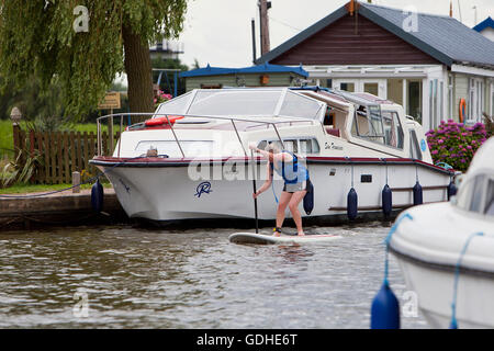 Norfolk Geräte, UK. 16. Juli 2016. Das sechste Norfolk Broads klassische SUP Rennen. Zehn und fünf Meile Kurse zwischen wie Hill Nature Reserve und Martham vorbei an den Ruinen von St. Benets Abbey, Thurne Windmühle und unter niedrigen mittelalterliche Brücke bei Potter Heigham, unzählige Urlaub Cruiser und Yachten auf dem Weg zu verhandeln. Mit Ursprung in Hawaii als Sport, Stand-up-Paddle-Boarding ist einer der neuesten Wassersport Großbritanniens und das Broads Classic, organisiert von Martham Boote, zieht Anfänger und erfahrene Rennfahrer aus der ganzen Land. Bildnachweis: Adrian Buck/Alamy Live-Nachrichten Stockfoto