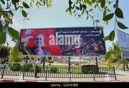 Khan Younis, Gazastreifen, Palästinensische Gebiete. 17. Juli 2016. Palästinenser gehen vorbei an ein Plakat mit einem Porträt der türkische Präsident Recep Tayyip Erdogan in Gaza-Stadt, am 17. Juli 2016. Das Schreiben in Arabisch lautet: '' Unterstützung Turkey.its kluge Führung und seine verbundenen Menschen. Sieg für die free.salute der Türkei Führer und seine Menschen ''. Türkische Behörden entrissen wieder die Kontrolle über das Land am 16. Juli nach Niederschlagung eines Militärputsches durch unzufriedene Soldaten versuchen, die Macht von Präsident Recep Tayyip Erdogan zu ergreifen, die mehr als 250 Menschen das Leben gekostet (Credit-Bild: © Ashraf Amr Stockfoto