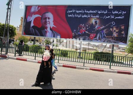 Khan Younis, Gazastreifen, Palästinensische Gebiete. 17. Juli 2016. Palästinenser gehen vorbei an ein Plakat mit einem Porträt der türkische Präsident Recep Tayyip Erdogan in Gaza-Stadt, am 17. Juli 2016. Das Schreiben in Arabisch lautet: '' Unterstützung Turkey.its kluge Führung und seine verbundenen Menschen. Sieg für die free.salute der Türkei Führer und seine Menschen ''. Türkische Behörden entrissen wieder die Kontrolle über das Land am 16. Juli nach Niederschlagung eines Militärputsches durch unzufriedene Soldaten versuchen, die Macht von Präsident Recep Tayyip Erdogan zu ergreifen, die mehr als 250 Menschen das Leben gekostet (Credit-Bild: © Ashraf Amr Stockfoto