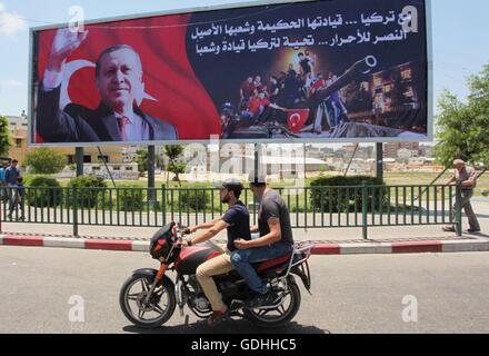 Khan Younis, Gazastreifen, Palästinensische Gebiete. 17. Juli 2016. Palästinenser gehen vorbei an ein Plakat mit einem Porträt der türkische Präsident Recep Tayyip Erdogan in Gaza-Stadt, am 17. Juli 2016. Das Schreiben in Arabisch lautet: '' Unterstützung Turkey.its kluge Führung und seine verbundenen Menschen. Sieg für die free.salute der Türkei Führer und seine Menschen ''. Türkische Behörden entrissen wieder die Kontrolle über das Land am 16. Juli nach Niederschlagung eines Militärputsches durch unzufriedene Soldaten versuchen, die Macht von Präsident Recep Tayyip Erdogan zu ergreifen, die mehr als 250 Menschen das Leben gekostet (Credit-Bild: © Ashraf Amr Stockfoto