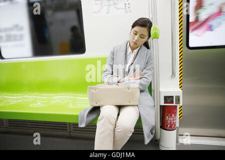 Müde von jungen Frauen auf der u-Bahn Stockfoto