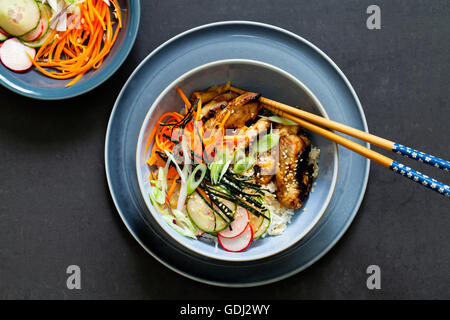 Orientalischen Schüssel mit Reis, karamellisierten Hähnchenschenkel und eingelegtes Gemüse Stockfoto