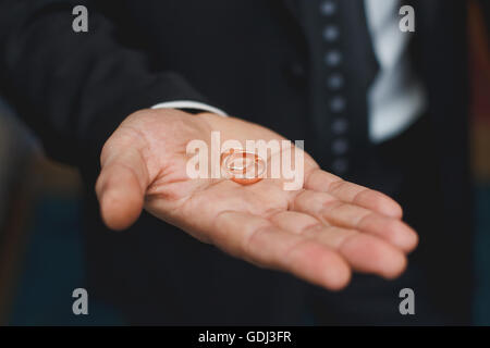 Zwei Trauringe in einer Hand des Bräutigams Stockfoto