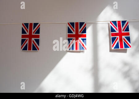 Union Jack-Flagge Wimpel hängen an einer weißen Wand. Stockfoto