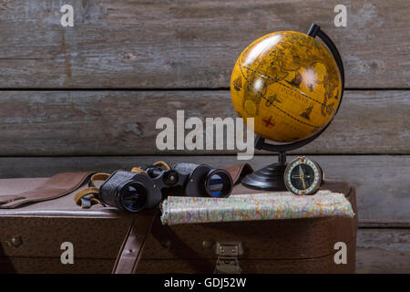Globus mit dem Fernglas auf Koffer. Stockfoto