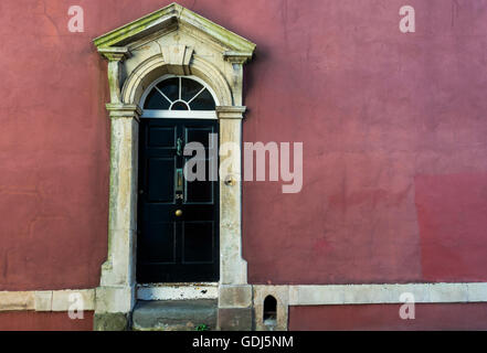 Schwarze Tür mit einer dunklen Rosa Wand, georgianische Architektur des Gebiets Kingsdown Bristol, UK Stockfoto