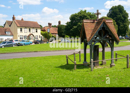 Der Dorfplatz von Brockham, Surrey, UK - im Vordergrund eine Hand Pumpe gut, und im Hintergrund The Royal Oak pub Stockfoto