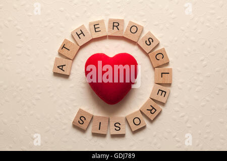 Das Wort Arteriosklerose gebildet mit Holzbuchstaben und ein Herz in der Mitte Stockfoto