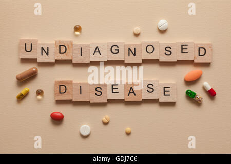 Die Wort nicht diagnostizierten Krankheit gebildet mit Holzbuchstaben und Pillen um Stockfoto
