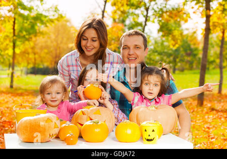 Familie schnitzen Kürbisse für Halloween im Garten Stockfoto