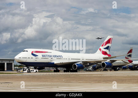Reihe von British Airways Flugzeuge mit einem anderen Flugzeug nähert sich im Hintergrund am Flughafen London Heathrow Stockfoto