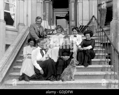 Edwardian Post-viktorianischen Ära UK mit einem eher informelle Gruppenfoto von dem, was könnten Hausbesitzer und Mitarbeiter Lächeln für die Kamera oder ein Gast-Haus-Besitzer und Personal. Beachten Sie die nicht gleichgültig Terrier Hund!  Foto von Tony Henshaw Stockfoto