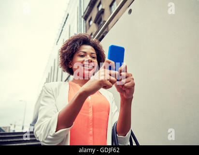 glücklich Afrikanerin mit Smartphone in Stadt Stockfoto