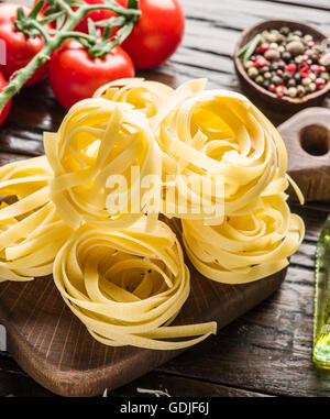 Pasta Zutaten. Cherry-Tomaten, Spaghetti Nudeln und Gewürze auf dem Holztisch. Stockfoto