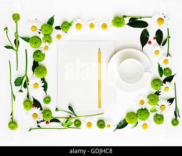 Papier, Bleistift und Becher für Kaffee oder Tee mit Kranz aus Kamille und Chrysanthemen Blumen, Ficus Blätter und Reife rowan Stockfoto