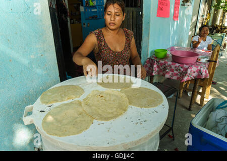 Mexikanerin Platzierung Mais-Tortillas auf ihr am Straßenrand flat Top Herd Stockfoto