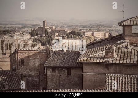 Ein Blick über den Dächern von Siena, mit Blick auf die mittelalterliche Basilika Santa Maria dei Servi. Siena ist eine alte toskanische Stadt. Stockfoto
