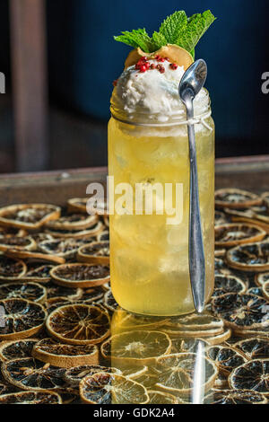 gelb-Orange und Wodka-cocktail mit Eis, Pfeffer und Minze Stockfoto