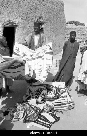 Ein Mann verkauft Teppiche auf dem Markt neben der großen Moschee von Djenne, 1959. Stockfoto