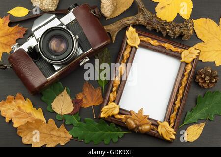 Rahmen für Fotos mit Eiche Blätter auf einem hölzernen Hintergrund. Wünsche auf eine Postkarte. Stockfoto