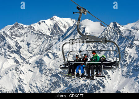 Skifahrer am Sessellift, Mont-Blanc-Massiv hinter Skigebiet Les Contamines-Montjoie, Haute-Savoie, Frankreich Stockfoto