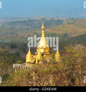 Goldene Stupa auf einem Hügel in der Landschaft. Kanchanaburi, Thailand Stockfoto