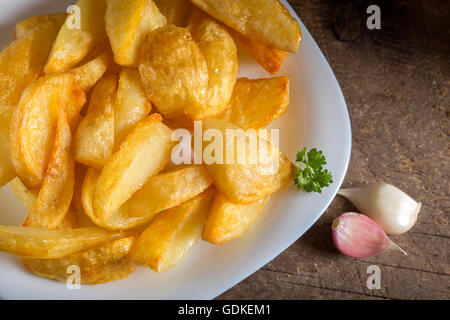 Portion hausgemachte Pommes Frites (Kartoffeln) auf weiße Platte und Holz rustikal Hintergrund Stockfoto