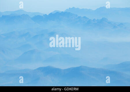 Berge unter Nebel am Morgen. Stockfoto