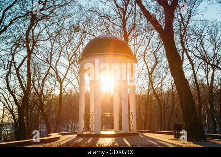 Sonne bei Sonnenuntergang durchschimmern Pavillon im Stadtpark in Gomel, Weißrussland. Garten-Pergola. Lens-Flare-Effekt. Stockfoto