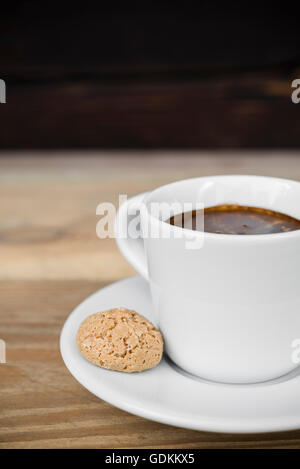 Tasse Espresso mit Biscotti auf alten rustikalen Holztisch angeordnet Stockfoto