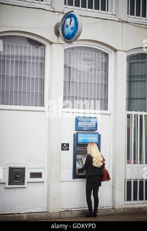 Wilmslow Barclays bank Geldautomat atm junge Dame Mädchen Frau sie mit Geldautomaten in der Stadt Straße Zentrum einzelne Nachttresor de Stockfoto