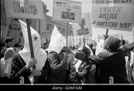 Ku Klux Klan-Mitglieder, die Unterstützung Barry Goldwaters-Kampagne für die Nominierung des Präsidentschaftskandidaten bei der Republican National Convention, San Francisco, Kalifornien, stößt als Afro-Amerikaner Mann Zeichen zurück. Warren K. Leffler, Fotograf. Stockfoto