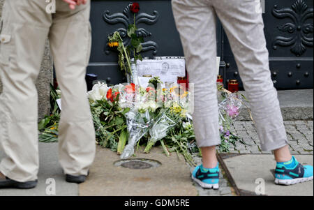 Leipzig, Deutschland. 18. Juli 2016. Passanten schauen Blumen und Kerzen Denkmal vor dem Eingang in die Firmenzentrale von Unister in Leipzig, Deutschland, 18. Juli 2016. Das Leipziger Internetunternehmen Unister eingereicht für Insolvenz - vier Tage nach dem Unfalltod ihres Leiters. Wagner starb bei dem Absturz von einem privaten Flugzeug in Slowenien am 14. Juli 2016. Foto: JAN WOITAS/Dpa/Alamy Live News Stockfoto