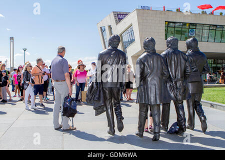 The Beatles Pier Head, beliebt, Bronzestatuen der vier Beatles, geschaffen von Bildhauer Andy Edwards und enthüllt im Jahr 2015. Touristen und Tagesausflügler kommen am Pier Head Development in Liverpool, Liverpool, Merseyside, Großbritannien, an. Stockfoto