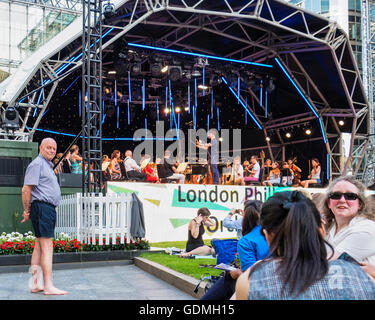 Canary Wharf, London, 19. Juli 2016. Londoner genießen Sie die Gratis-Konzert in Canada Square Park. Das London Philharmonic Orchestra wurde von Matthew Coorey durchgeführt. Die Musikliebhaber drängten sich in den Park mit Decken und Picknickkörben und den warmen Sommerabend genossen, wie Temperaturen einen hohen Sommer erreicht. Bildnachweis: Eden Breitz/Alamy Live-Nachrichten Stockfoto