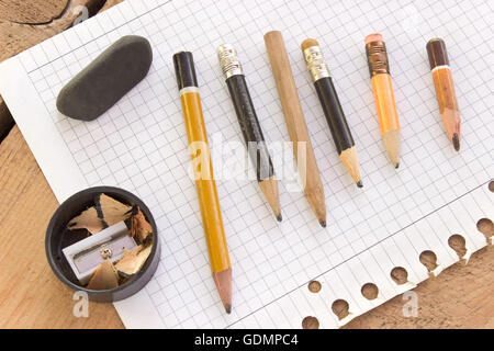 Gebrauchte Stifte und Papier auf Holztisch Stockfoto