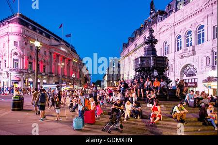 Leute sitzen herum und die Eros-Denkmal-Piccadilly Circus-London UK Stockfoto