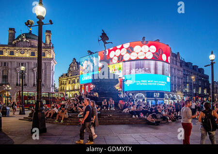 Leute sitzen herum und die Eros-Denkmal-Piccadilly Circus-London UK Stockfoto