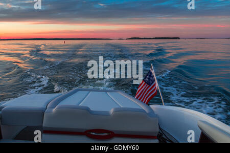 Bootsfahrten bei Sonnenuntergang mit Stern, amerikanische Flagge und Wasser. Stockfoto