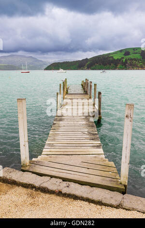 Alte hölzerne Pier Steg über der Küste an Akaroa, Neuseeland Stockfoto