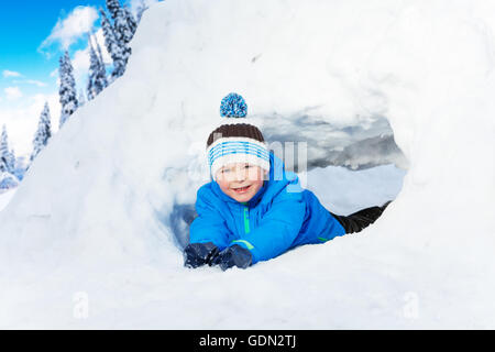 Kleiner Junge Crawl durch Schnee Tunnel im park Stockfoto