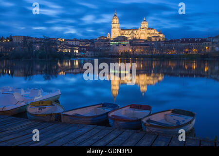 Salamanca - die Kathedrale und Brücke Puente Enrique Estevan Avda und des Rio Tormes-Flusses in der Abenddämmerung. Stockfoto