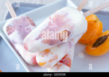 Hausgemachte Pfirsich Aprikose und orange Eis am Stiel auf weißen Teller mit frischem Obst, behandelt Sommer Stockfoto