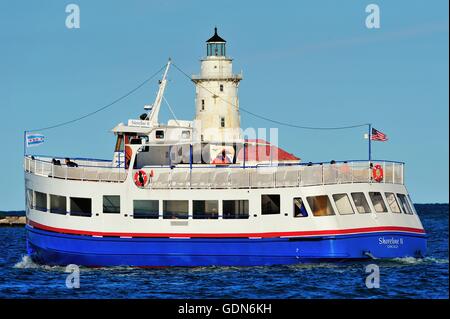 Ein wassertaxi Verdoppelung als Tour Boot an der Vorderseite des Chicago Hafen Leuchtturm an einem Sommerabend. Chicago, Illinois, USA. Stockfoto